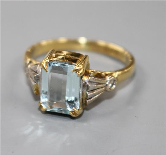 An 18ct and emerald cut aquamarine dress ring, with diamond set shoulders, size N.